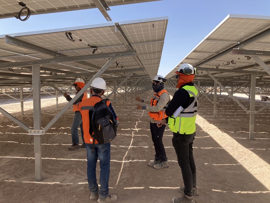 Equipo de trabajo montando módulos fotovoltaicos bajo trackers